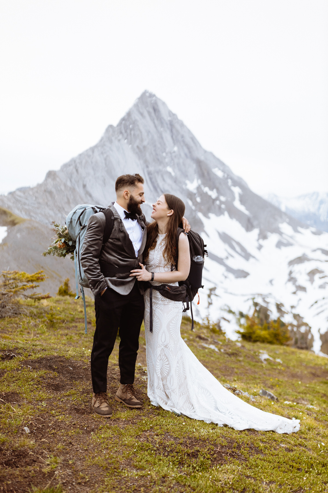 Hiking wedding with floral bouquet in backpacks