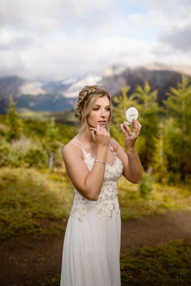 Bride applying makeup during a hiking elopement